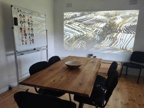 Dining table and chairs with projector on wall