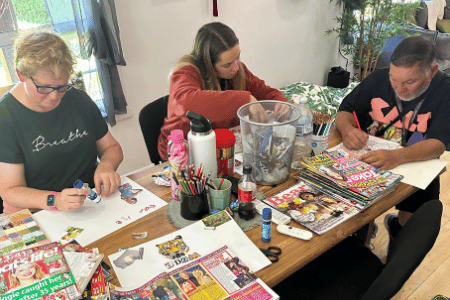 Arts and craft session at kitchen table with two participants and support worker