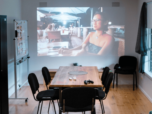Dining room with table and 6 chairs with TV projector on wall