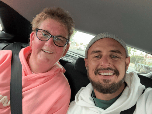 Support worker with NDIS participant in back of car