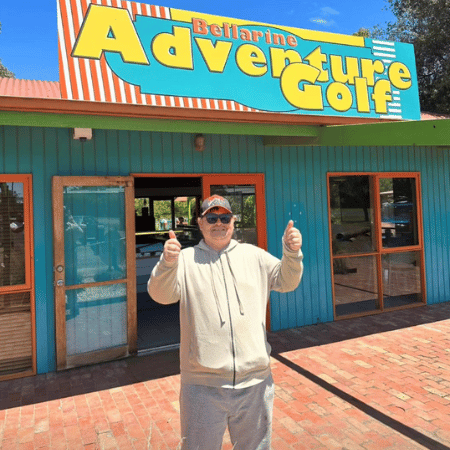 A man posing in front of Adventure Golf