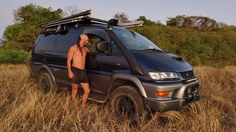 A man standing beside his van
