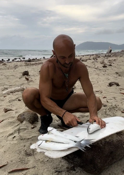 A man preparing fish on the beach