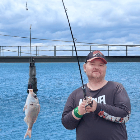 A man posing for a photo with a fish